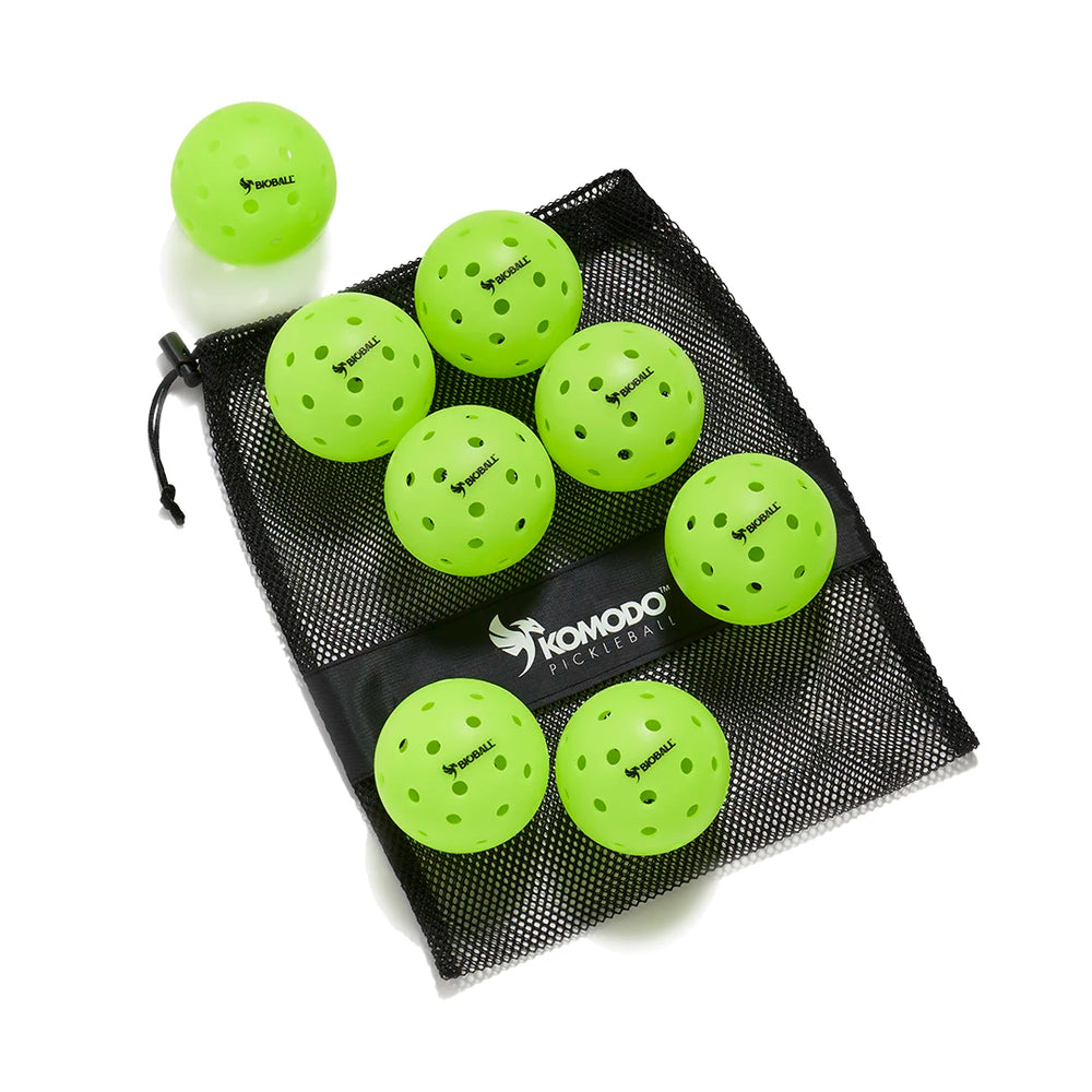 Green pickleballs with a black mesh bag on a white background